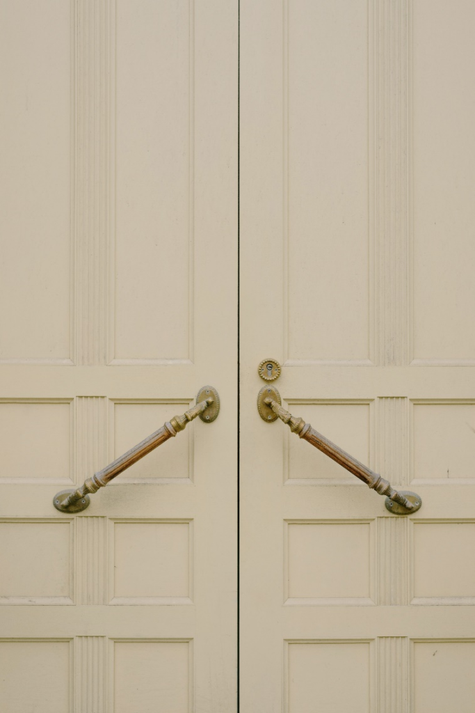 a white wooden door with metal handles