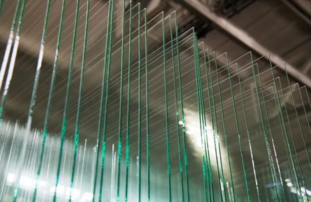 Stack of laminated glass sheets in a manufacturing facility, showcasing the durability and safety features 