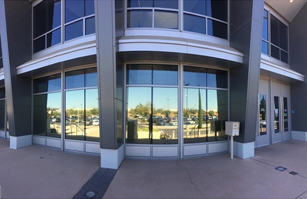 Modern commercial building with mirrored glass reflecting the surroundings and showcasing energy efficiency and sleek design.